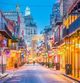 empty street lined with bars and restaurants with neon signs