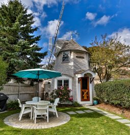Quaint windmill turned house with table and chairs in front in the yard