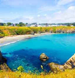 Stunning turquoise cove with Mendocino Main Street Houses in the distance