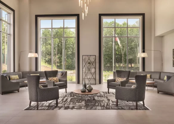 hotel lobby with grey seating and large windows that begin at the floor