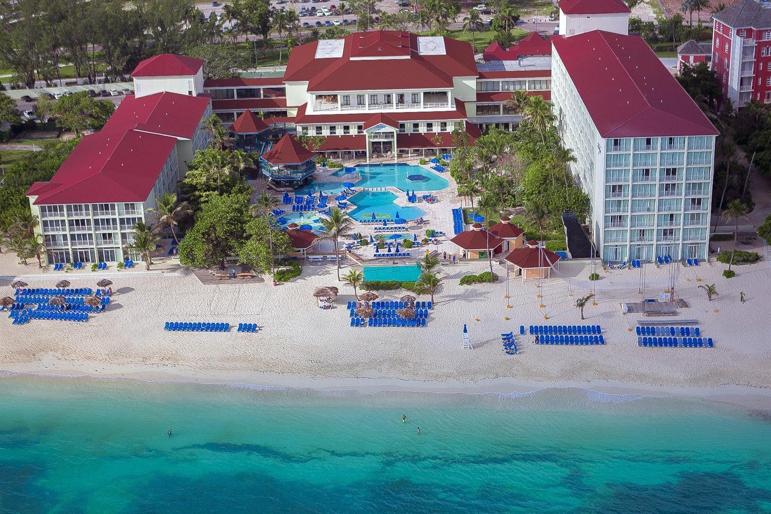 Red-topped resort buildings set on the white sand