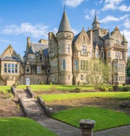 exterior of castle with lush lawn and trees