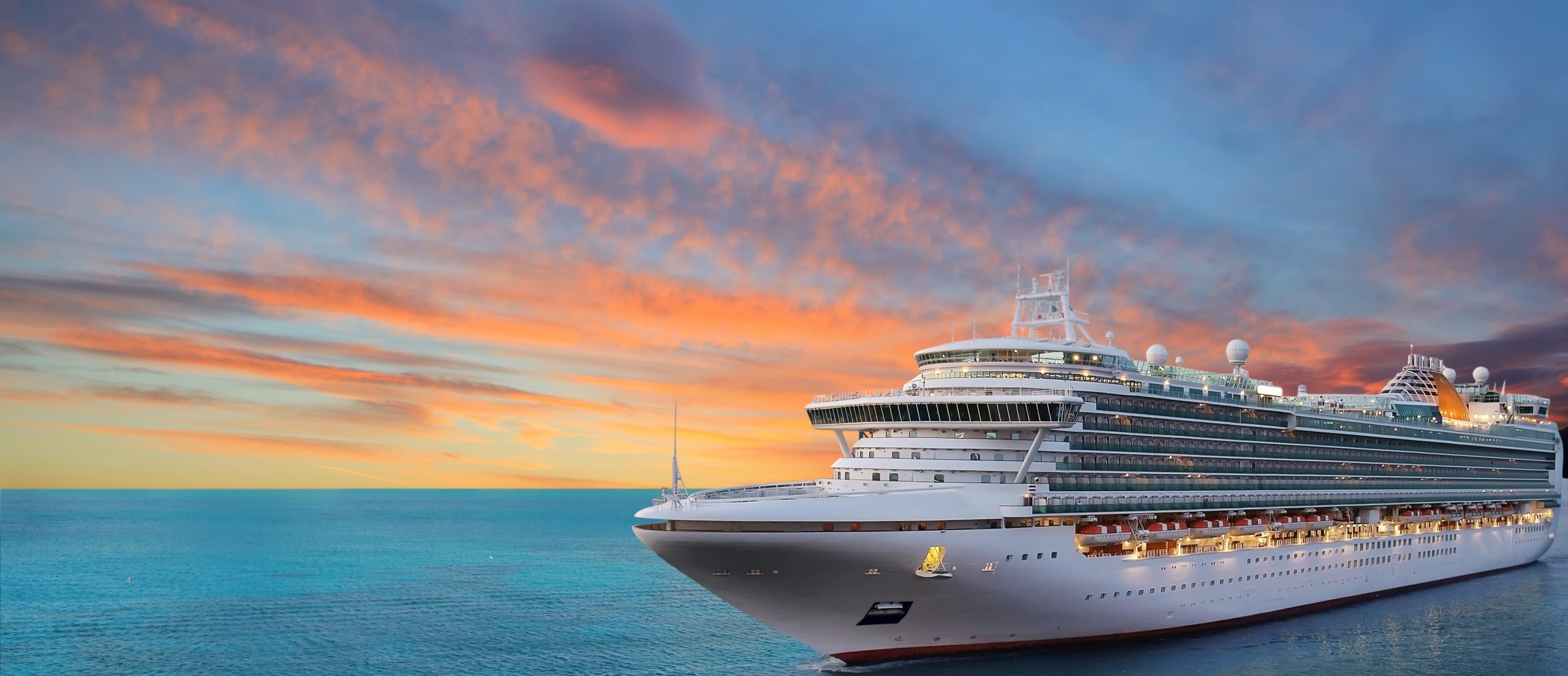 Luxury cruise ship sailing to port on sunrise